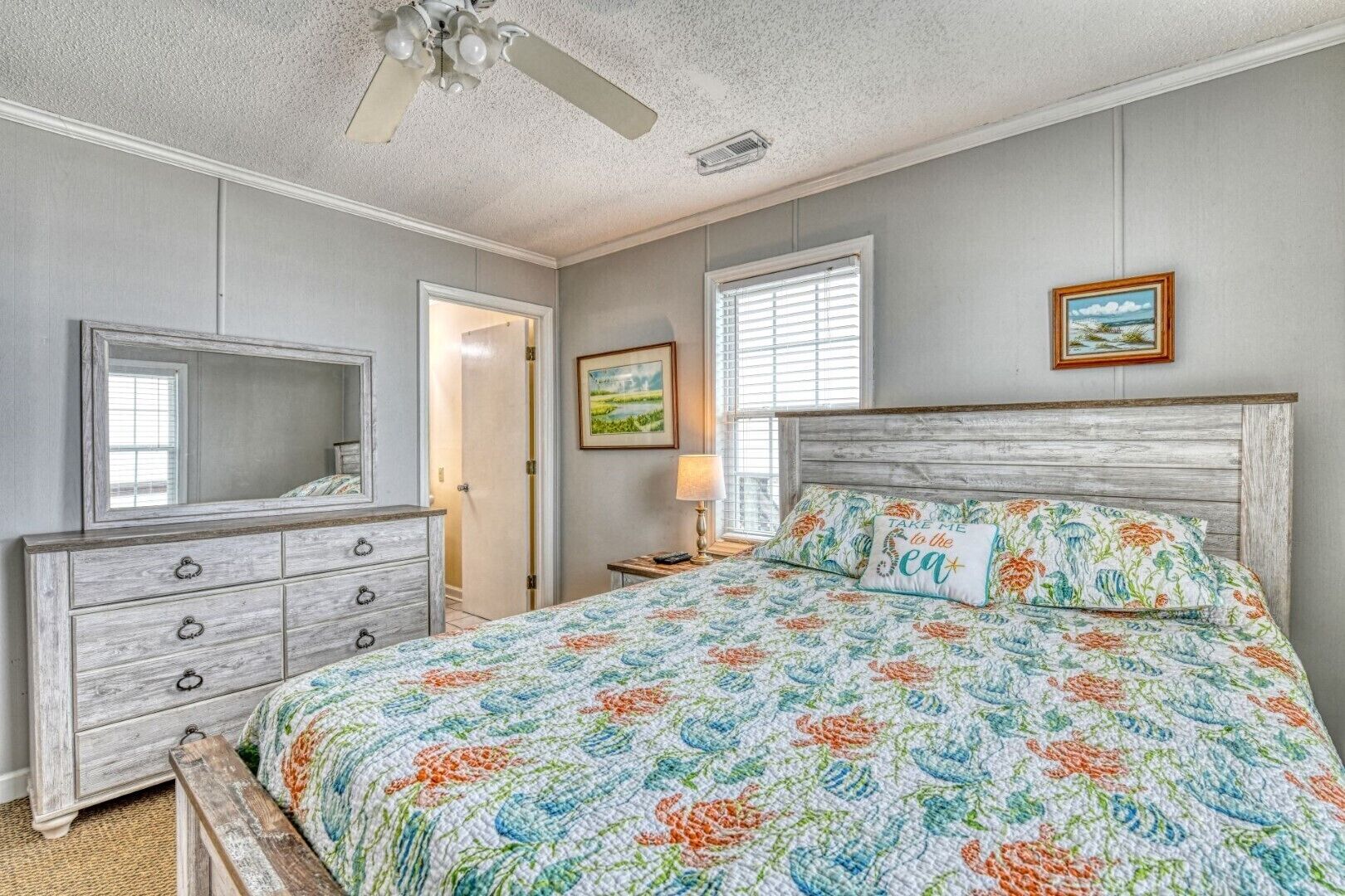 Une chambre à coucher avec un lit, une commode et un ventilateur de plafond.