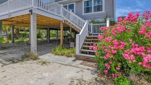 A two-story house with a covered porch and a staircase leading to the upper floor. - Love's A Beach - 5 Bedroom. 4 Bathroom, Oceanfront Dog Friendly Home (Garden City Beach)