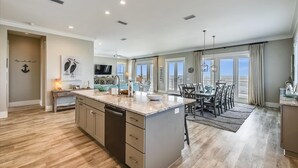 Una cocina amplia con una isla grande, suelo de madera y un comedor con vistas.