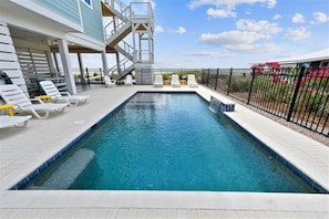 A rectangular pool with a white deck and a metal staircase leading to a higher level. - THE WAIT IS OVER!  PAPAW'S SANDBOX IS READY! (St. George Island)