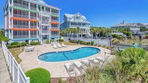 A multi-story hotel with a pool area, including lounge chairs and a clear blue pool. - Compass Rose 11, three-bedroom, two-bath condo, ocean front (Garden City Beach)