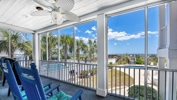 A covered outdoor area with a pool, chairs, and a view of the ocean. - Compass Rose 11, three-bedroom, two-bath condo, ocean front (Garden City Beach)