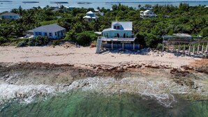 A beachfront property with multiple buildings, clear waters, and boats in the distance. - High Hopes: Charming Oceanfront Cottage on the North End of Elbow Cay (Elbow Cay)