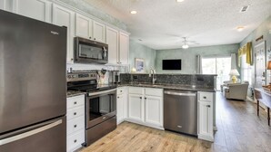 A modern kitchen with white cabinets, stainless steel appliances, and a granite countertop. - Better Twin - Five Bedroom, Four 1.5 Bath Beach House with Ocean Views (Surfside Beach)