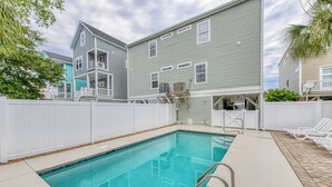 A swimming pool with a white fence and a covered area with chairs. - Better Twin - Five Bedroom, Four 1.5 Bath Beach House with Ocean Views (Surfside Beach)