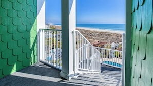 Ein Balkon mit Blick auf Strand und Meer.