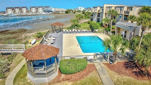 A pool area with lounge chairs, a small gazebo, and a view of the beach and ocean. - Inlet Pointe 30 Inlet front condo with pool, fishing dock and Walk to beach (Garden City Beach)