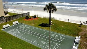 Ein Shuffleboardfeld neben einem Strand mit Blick auf das Meer.
