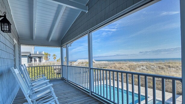 A covered outdoor area with a pool, wooden deck, and a view of the beach. - Lazy O - Four Bedroom, Three 1/2 Bath Oceanfront Home with Private Pool (Garden City Beach)