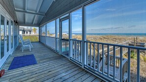 A covered porch with a view of the beach and ocean. - Lazy O - Four Bedroom, Three 1/2 Bath Oceanfront Home with Private Pool (Garden City Beach)