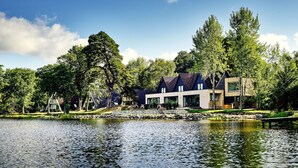 Une propriété au bord du lac, dotée d’une architecture moderne, d’un quai et d’un jardin bien entretenu.