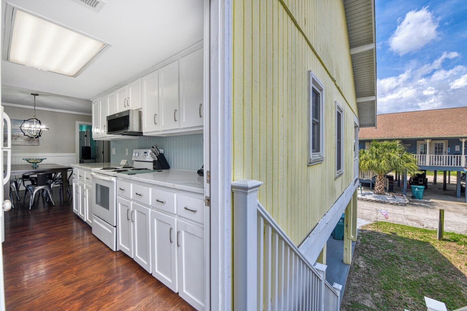 A kitchen with white cabinets, a microwave, and a dining area with a table and chairs.