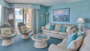 A room with a view of the ocean, featuring a sofa, two armchairs, a small round table, and a floor lamp. - Surfmaster 103 - Three-bedroom, three-bath first-floor oceanfront condo (Garden City Beach)