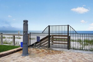 A beach gate with a sign encouraging visitors to keep the beach clean.
