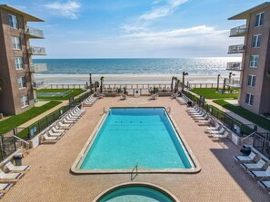 A swimming pool with lounge chairs and a view of the beach. - Watch the sunrise over the No Drive Beach in NSB! (New Smyrna Beach)