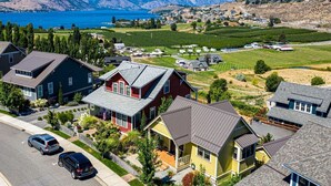A residential area with houses, a road, and a lake in the background. - Northern Lights at Chelan Lookout Vacation Rentals (Chelan)
