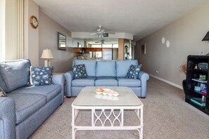 A living room with a sofa, a coffee table, and a bookshelf.