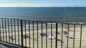 A beach with a metal railing, sandy shore, and a clear sky. - Cozy 2 Bedroom Oceanfront Condo (MURRELLS INLET)