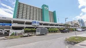 A hotel with a large parking structure, a sign for Royal Garden, and a 1210 building. - Cozy 2 Bedroom Oceanfront Condo (MURRELLS INLET)