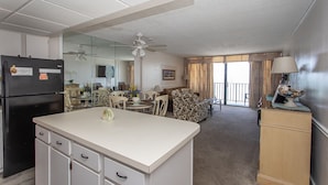 A compact living space with a kitchenette, dining area, and a balcony. - COZY 1 BEDROOM CONDO IN GARDEN CITY (MURRELLS inlet)