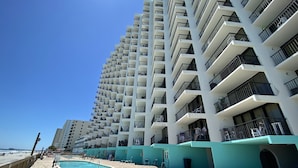 A high-rise hotel with multiple balconies, a pool area, and a beach view. - COZY 1 BEDROOM CONDO IN GARDEN CITY (MURRELLS inlet)