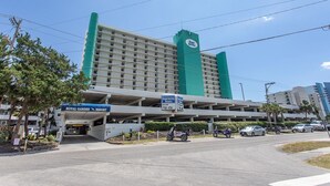 A multi-story hotel with a green and white color scheme, featuring a sign for the Royal Garden Resort. - Immaculate, flawless two bedroom condo (Murrells Inlet)