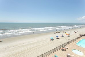A beach with a pool, umbrellas, and lounge chairs. - Beautiful Ocean Front 3 Bedroom Condo (Murrells Inlet)