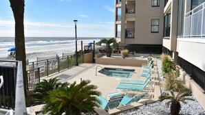 A pool area with lounge chairs, a small pool, and a view of the beach. - Surfmaster 909 - One-bedroom, one-and-a-half-bath oceanfront condo with pools (Garden City Beach)
