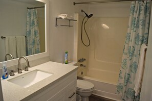A bathroom with a sink, toilet, and shower.