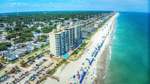 A coastal hotel with multiple floors, a beachside location, and a parking area. - One Ocean Place 804 - Spacious three-bedroom, three-bath oceanfront condo (Garden City Beach)