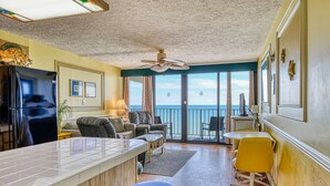 Un'ampia zona giorno con cucina, un balcone con vista e una ventola a soffitto.