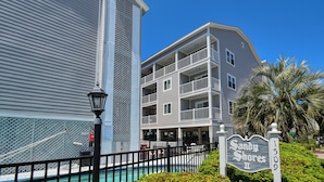 A multi-story hotel with balconies, a pool, and a sign reading "Sandy Shores II". - Sandy Shores II 209 - Two-bedroom, two-bath oceanview condo in GCB (Garden City Beach)