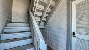 A staircase with wooden steps and white railings leading to a closed door. - Sea Watch VIII 103 - Two Bedroom, One Bath Oceanfront Condo (Garden City Beach)