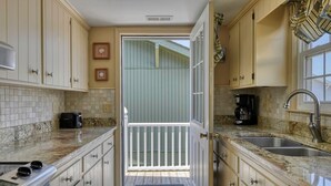 A kitchen with a view to a deck, a coffee maker, and a toaster. - Summer House - Clinkscales - Three-bedroom, two-bath beach house with Wi-Fi (Garden City Beach)