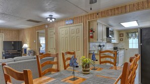 A dining area with a table, chairs, and a kitchen in the background. - Summer House - Clinkscales - Three-bedroom, two-bath beach house with Wi-Fi (Garden City Beach)