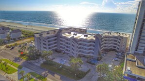 Un hotel a più piani con una terrazza panoramica affacciata su una spiaggia e l'oceano.