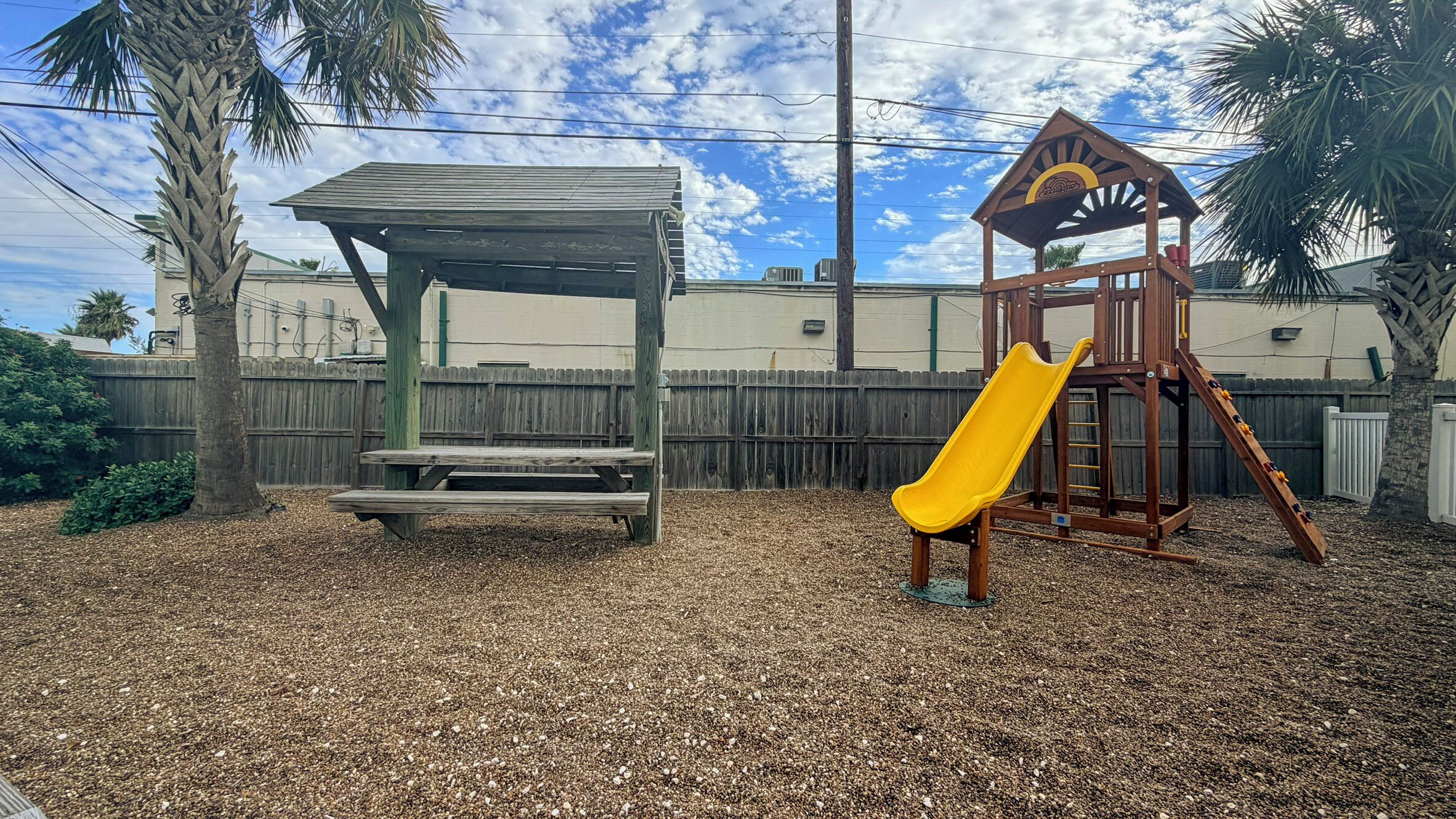 A playground with a wooden slide and a picnic table.