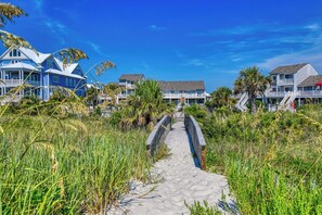 A coastal pathway leading to beachfront properties with a clear sky. - Gulf Stream Villa 113 (Garden City Beach)