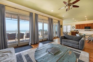 A spacious living area with a view of the ocean, a dining area, and a kitchen.
