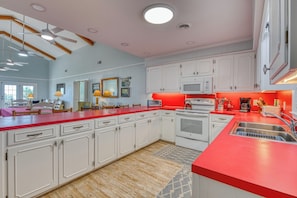 A spacious kitchen with white cabinetry, a red countertop, and a built-in oven.