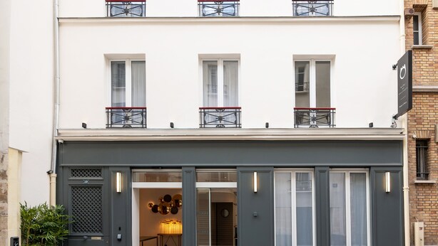 A modern building with a grey facade, large windows, and a balcony with a metal railing. - Hotel au coeur des Arts et Metiers (Paris)