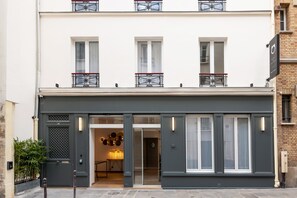 A modern building with a grey facade, large windows, and a balcony with a metal railing. - Hotel au coeur des Arts et Metiers (Paris)
