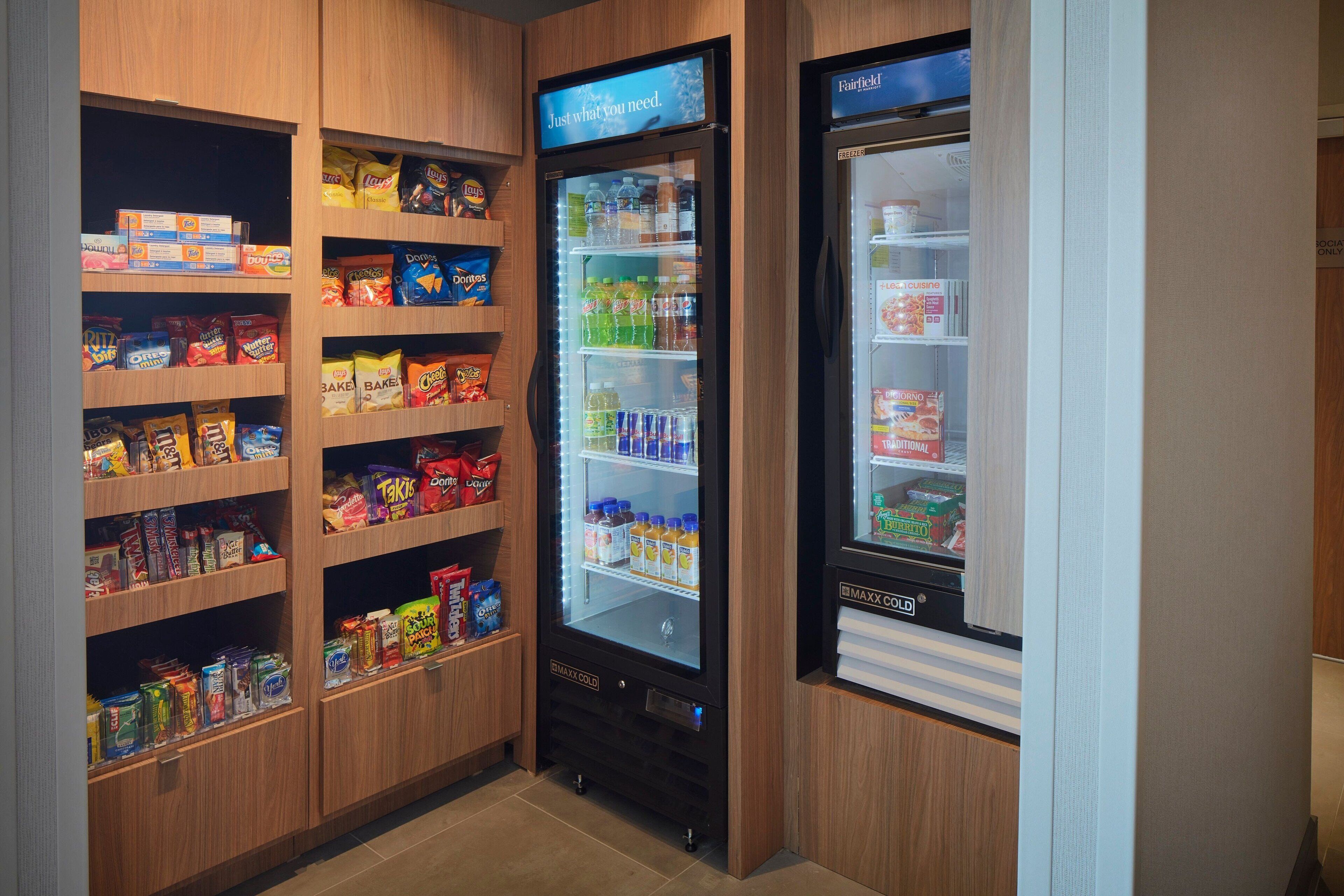 Un espace de vente proposant des collations et des boissons, avec un assortiment varié de produits et un compartiment réfrigéré.