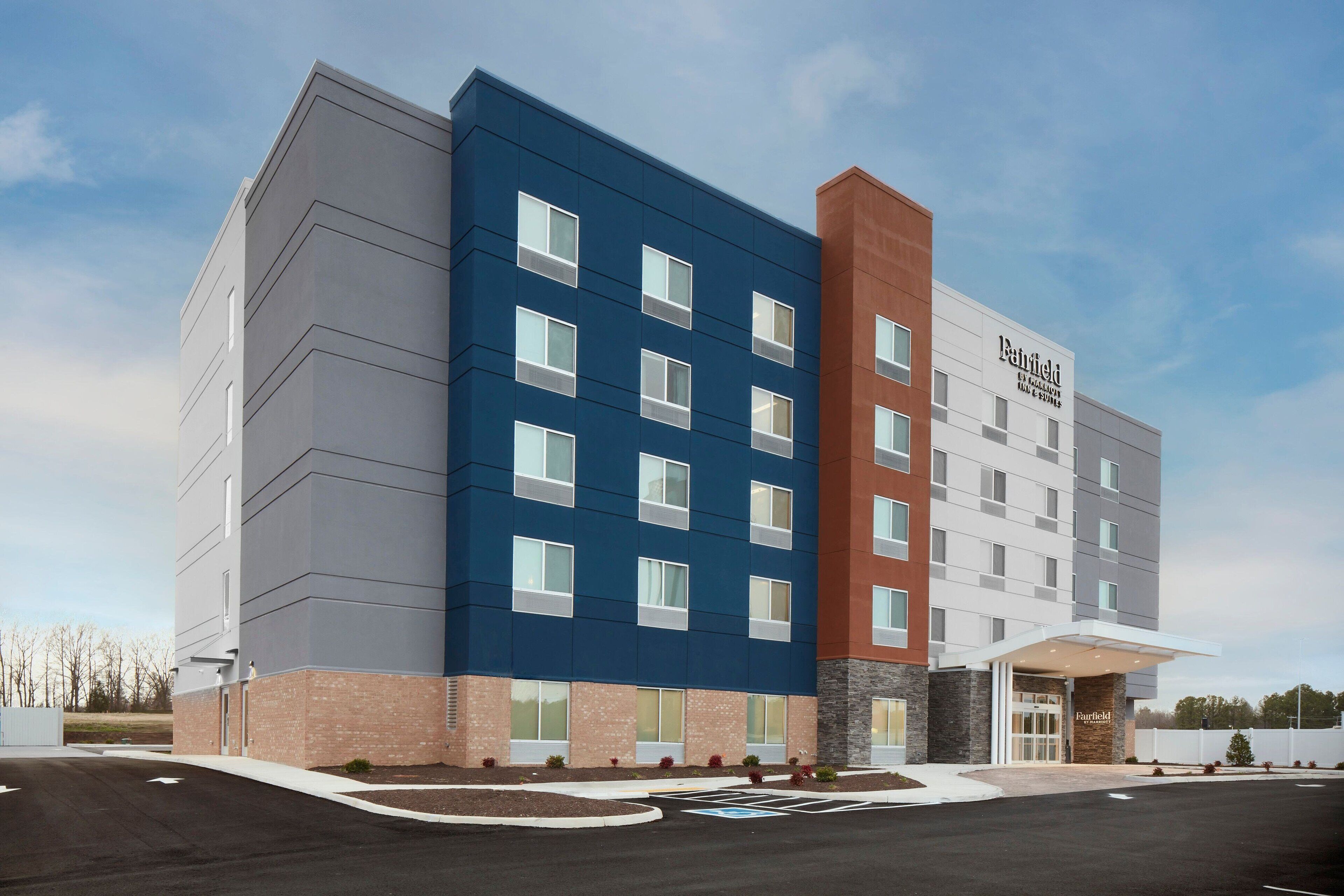 A multi-story hotel with a modern design, featuring a mix of blue and brown exterior colors.