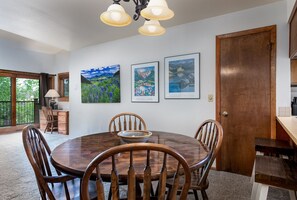 Enjoy meals in this dining area with a round table and six chairs, surrounded by framed artworks and a window with a view.