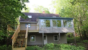 A two-story house with a wooden staircase leading to the upper floor.