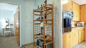 Eine kleine Küche mit Holzschränken, einem Einbauofen und einer Mikrowelle.