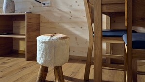 Un suelo de madera, un banco de madera y un taburete pequeño con un asiento mullido.