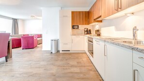 Une cuisine moderne avec des armoires blanches, un comptoir en granit et des appareils électroménagers en acier inoxydable.