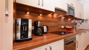 Een moderne keuken met roestvrijstalen apparatuur, houten aanrechtbladen en witte keukenkastjes.